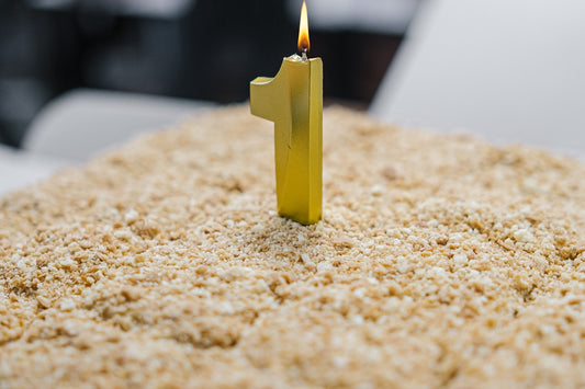 a small yellow candle sitting on top of a cake