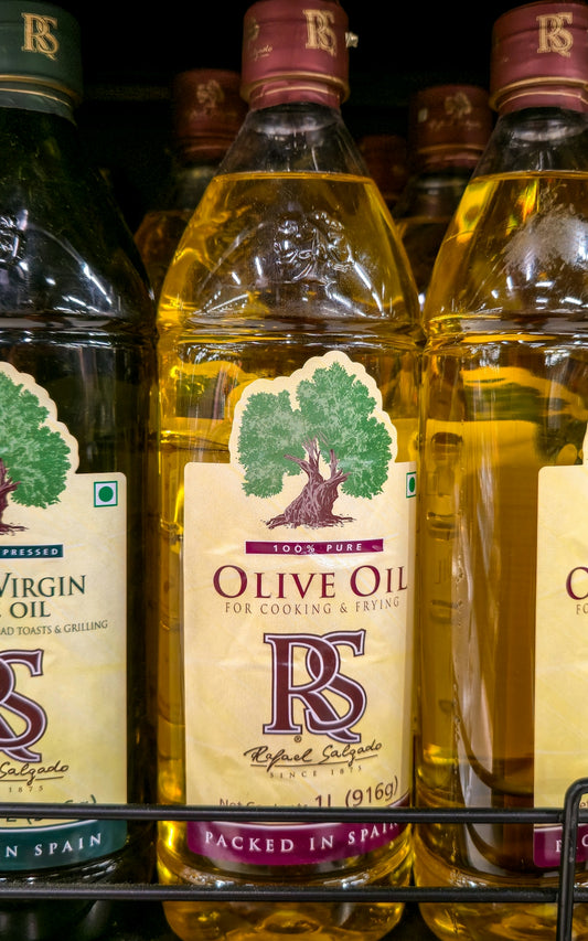 Bottles of pure olive oil on a shelf.